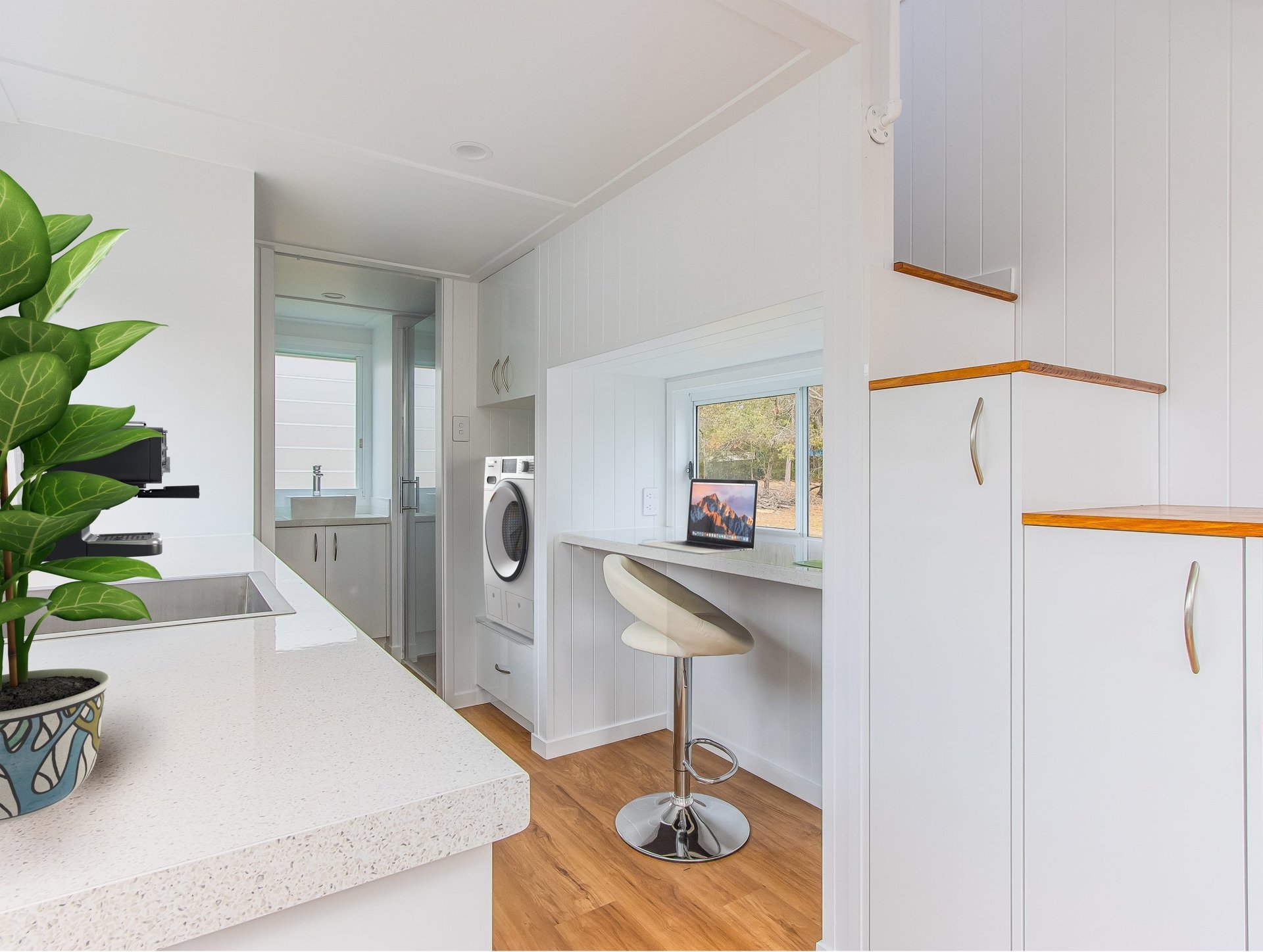 A tiny home interior set up with a laptop at a benchtop as a quiet home office nook